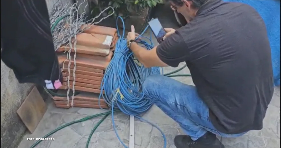 Empresa de Internet Interditada por Uso de Cabos Furtados em Duque de Caxias" Uma operação da Polícia Civil resultou na interdição de uma empresa de internet em Duque de Caxias, na Baixada Fluminense, por envolvimento no uso de cabos furtados em seus serviços. Durante a ação, agentes flagraram dois funcionários, identificados pelos adesivos da empresa em seus carros, realizando um serviço no bairro Taquara sem a documentação adequada para os cabos utilizados. Os funcionários não possuíam comprovação para a utilização dos cabos, e ao serem abordados, indicaram o responsável pela empresa. As investigações levaram os policiais até a sede da companhia, onde mais um funcionário foi encontrado. No local, foram descobertos diversos cabos que traziam a identificação de duas empresas de telefonia. A operação culminou na prisão dos envolvidos, que foram autuados por receptação qualificada, reforçando a atuação enérgica da polícia na repressão de atividades ilícitas