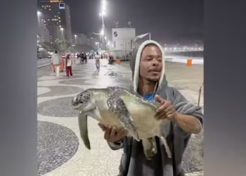 Homem é flagrado com tartaruga marinha nas mãos em Copacabana