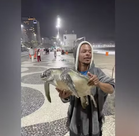 Homem é flagrado com tartaruga marinha nas mãos em Copacabana