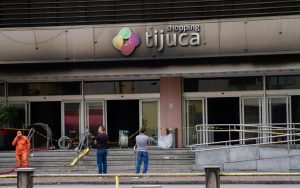 Clientes tentam recuperar carros e pertences deixados no Shopping Tijuca após incêndio; acesso ocorre de forma controlada.