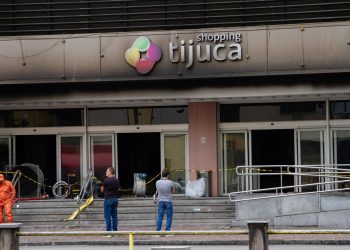 Clientes tentam recuperar carros e pertences deixados no Shopping Tijuca após incêndio; acesso ocorre de forma controlada.