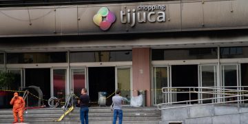 Clientes tentam recuperar carros e pertences deixados no Shopping Tijuca após incêndio; acesso ocorre de forma controlada.